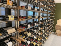 36 - This custom metal racking includes brushed stainless steel posts, white oak supports, and aluminum rods. Metal rod wine racking in modern Orange County residential wine cellar