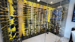 38 - A stunning contemporary home wine cellar with floor-to-ceiling cable racking and frameless glass doors. modern home wine cellar frameless glass doors and metal cable racking